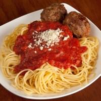 plate of spaghetti and meatballs in marinara sauce