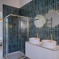Ruime badkamer met dubbele lavabo en douche
