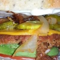 Side View of Vegan Burger with onions , pickles, lettuce , tomato and advocado