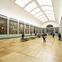 A modern museum with large paintings hanging on each wall A modern museum with large paintings hanging on each wall