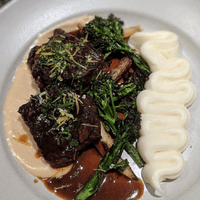 Red wine braised shortribs, carmelized onion crema, potato puree, grilled rapini, gremolata