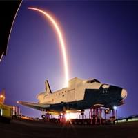 launch of Dragon Cots 2 over a KSC space shuttle model