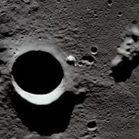 Looking down at the Command and Service Module (center), with the Moon's surface below, as seen from the now-separated Lunar Module (LM), on its way to the surface. The proiminent crater is Schmidt crater. This is the last photo taken from the LM prior to the powered descent, and eventually the landing one orbit later. (NASA) #