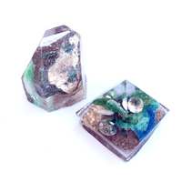 Emily Budd Memory Orgonites, gifts for the daughters of Nicholas Farah (2), 2021 Items from Nicholas’s collection including stones, minerals and jewelry, in cast resin. Each 1 ½” x 1 ¾”  NFS | Nicholas Farah collected gems and minerals, he had a good eye for the wonders contained within. These gems are for his two daughters, whose father was stolen from them.  Emily Budd Memory Orgonites, gifts for the daughters of Nicholas Farah (2), 2021 Items from Nicholas’s collection including stones, minerals and jewelry, in cast resin. Each 1 ½” x 1 ¾”  NFS | Nicholas Farah collected gems and minerals, he had a good eye for the wonders contained within. These gems are for his two daughters, whose father was stolen from them.