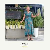 Relaxed and happy woman on vacation in Hoi An's An Bang area wears the bespoke tailored silk dress she commisioned there