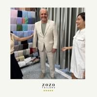 Standing with his tailor at her An Bang beach studio, a mature man looks happy in his new bespoke linen suit.