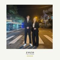 Mother and teen son stand in the evening lights of Hoi An's An Bang beach area wearing their new bespoke tailored suits.