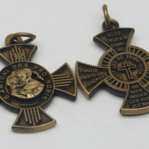 The Cross or Brief of St. Anthony Exorcism Medal a Replica of the Original Early 1900's version. 3 options Available. Antique Tin Antique Gold Antique Bronze Size: 34mm x 34mm. Material: Zinc Alloy. Weight: 12 grams This Medal is double sided please see pictures. The Brief of St Anthony on ones side and on the other St Anthony with the Child Jesus and a lilly, IHS and St Anthony Pray for us, In Latin. The first part of this powerful short prayer is already present in the Holy Scriptures in the Book of Apocalypse where, in Chapter 5 Verse 5 we read: “Vicit Leo de tribu Iudae, radix David” (The Lion of the tribe of Judah, the root of David, has triumphed). Furthermore, we can also find the prayer of St. Anthony’s Brief – that has an undoubted exorcistic value – in the two Rituals of Exorcism, today in use to the Catholic Church: both in the 1614 Old Ritual and in the 2004 New Ritual issued by John Paul II. The words of this Brief are powerful and can be used when feeling tempted by evil, oppressed by demons, and in general spiritual warfare. The exorcizing proclamation is carried on the person or placed in homes. THE BRIEF OR BLESSING OF SAINT ANTHONY A case of diabolical obsession, that yielded to the power of St Anthony of Padua, was recorded in Portugal during the reign of King Denis. Under the guise of a heavenly visitant, the devil frequently appeared to a woman of Lisbon and urged her to throw herself into the river Tagus in order to obtain the remission of her sins and eternal happiness. The tormented woman at length decided to drown herself. Passing a Franciscan chapel on her way to the river, she entered, and kneeling before the altar of St. Anthony, implored the Saint to help her save her soul. Overcome by fatigue, she fell asleep. During her slumber St Anthony appeared to her, revealed the deceit of the "father of lies" and released her from the obsession. On awaking, the woman found a letter which the Saint had given her during the vision. It contained the prayer now known as the "Brief of St Anthony." The original of Saint Anthonys Brief was preserved with the crown jewels by the King of Portugal. Pope Sixtus V caused the efficacious lines to be inscribed on an obelisk, which he had erected in the quadrangle in front of Saint Peter's. The words of this Brief are powerful and can be used when feeling tempted by evil, oppressed by demons, and in general spiritual warfare. The exorcizing proclamation is carried on the person or placed in homes.