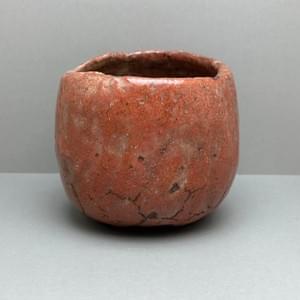 花仙人(加藤長一)作の赤楽茶碗。赤褐色の釉調と手捏ねによる造形 A red Raku tea bowl by Hanasennin (Nagakazu Kato), featuring a reddish-brown glaze and hand-pinched form