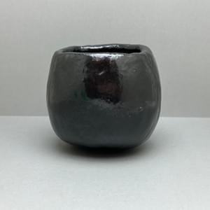 花仙人(加藤長一)作の黒楽茶碗。歪みのある口縁と手捏ねによる造形 A black Raku tea bowl by Hanasennin (Nagakazu Kato), with an irregular rim and hand-pinched form