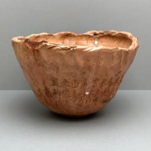 花仙人(加藤長一)作の赤楽茶碗。赤褐色の釉調と手捏ねによる造形 A red Raku tea bowl by Hanasennin (Nagakazu Kato), featuring a reddish-brown glaze and hand-pinched form
