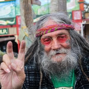 "I was born in Broken Hill. My parents moved when I was only three to Adelaide. Dad used to work underground in the mines. It was a pretty dangerous occupation so once he started having a family he thought he’d better stop this. I was brought up in Adelaide and it was boring. I went to Perth and was there for a while. I bought a motorcycle – a Triumph and hanged around with bikies for years. I was a hippie first though and I was going to come up here (Nimbin) but instead of that, like I said in 1978, I went to Perth and I ended up with the motorcycle crew. In 1993, I came up here. I met a beautiful woman and we had five children together. I’m not with her anymore because I got cancer and she was really busy with the kids, they were young and it was about five or six years ago now. She couldn’t look after me and the kids. Nimbin saved my life! It’s just such a beautiful place. (I’ve only ever been to New Zealand for a few weeks.) It’s relaxed and you can chill and grow a bit of pot if you can and find a bit of land. The most beautiful moment of my life was every time my wife had a baby. Every time you get the same feeling, the same rush. It’s the best feeling. You come out of the hospital. Woohoo…on top of the world. Another beautiful baby. A baby drug would be the best selling drug in the world if you could sell it. It’s such a buzz. It’s hard work for them but I was there for the birth, the attitude had changed. Not like the old way when dads had to wait outside and they didn’t get to take the baby. It’s all different now. I used to help in the Nimbim museum but it burnt down a few years ago in a fire. Id di that for 22 years. The rainbow café which was owned by the hippies. You can just see the colours of the rainbow serpent. It used to go right through the museum. You just follow the rainbow serpent. It was pretty big in the Aboriginal dream time of creation of things. It created all the rivers and mountains. The original Aquarius was in 1973. I got here just in time for the 20th anniversary of it and it was a really good time to get here because there were all these people in the hall talking about their experiences and that. I didn’t hear that much about Nimbin, a few people had filled me in a bit but if you just go and sit in the hall for a couple of hours over the couple of weeks of celebration and it just taught me about Nimbin. I was going to come up here and I was going to bring speed up here from Melbourne. I was going to get it brought up but when I got up here thought I’m not going to bring speed into this town. This is so chilled out and beautiful, you know. Somehow I ended up with the museum crew. Otherwise, I would probably have ended up on the other side of the road with all these junkies. They used to be all over that side. Like, I’d never been into heroin but that’s where I was heading. But I was gambling and stuff on horses, horse-racing at the TAB. I lost a lot of money. The most important thing I learned? That’s a big question. I don’t know. Treat people how you want to be treated or expect to be treated. Just mellow out, just relax. It’s all going to happen anyway. Don’t stress. Chill out man. Have another joint. That the only dug now. That’s the only drug I take now. Marijuana. That’s it. Nothing else. No alcohol, no tobacco. I don’t smoke marijuana anymore, I use a vapouriser. My lung are stuffed from many years of smoking cigarettes and joints. They said you’ve gotta give up smoking. “Your lungs are fucked!” I said, “But I have!” He goes “No, you’ve got to stop smoking marijuana too. That’s just as bad.  That’s got all these tars in it too.”  So then I went onto a vapouriser. It doesn’t actually burn the pot. It heats it up to a temperature where you can get stoned but you don’t burn it so you don’t get the tar. My lungs have cleared in the last three years but because of my cancer I’ve got to get yearly X-rays. There’s been a visible improvement in my lungs since I stopped smoking. There’s a chance the cancer will come back so I’ve started on medicine again but no chemo this time." "I was born in Broken Hill. My parents moved when I was only three to Adelaide. Dad used to work underground in the mines. It was a pretty dangerous occupation so once he started having a family he thought he’d better stop this. I was brought up in Adelaide and it was boring. I went to Perth and was there for a while. I bought a motorcycle – a Triumph and hanged around with bikies for years. I was a hippie first though and I was going to come up here (Nimbin) but instead of that, like I said in 1978, I went to Perth and I ended up with the motorcycle crew. In 1993, I came up here. I met a beautiful woman and we had five children together. I’m not with her anymore because I got cancer and she was really busy with the kids, they were young and it was about five or six years ago now. She couldn’t look after me and the kids. Nimbin saved my life! It’s just such a beautiful place. (I’ve only ever been to New Zealand for a few weeks.) It’s relaxed and you can chill and grow a bit of pot if you can and find a bit of land. The most beautiful moment of my life was every time my wife had a baby. Every time you get the same feeling, the same rush. It’s the best feeling. You come out of the hospital. Woohoo…on top of the world. Another beautiful baby. A baby drug would be the best selling drug in the world if you could sell it. It’s such a buzz. It’s hard work for them but I was there for the birth, the attitude had changed. Not like the old way when dads had to wait outside and they didn’t get to take the baby. It’s all different now. I used to help in the Nimbim museum but it burnt down a few years ago in a fire. Id di that for 22 years. The rainbow café which was owned by the hippies. You can just see the colours of the rainbow serpent. It used to go right through the museum. You just follow the rainbow serpent. It was pretty big in the Aboriginal dream time of creation of things. It created all the rivers and mountains. The original Aquarius was in 1973. I got here just in time for the 20th anniversary of it and it was a really good time to get here because there were all these people in the hall talking about their experiences and that. I didn’t hear that much about Nimbin, a few people had filled me in a bit but if you just go and sit in the hall for a couple of hours over the couple of weeks of celebration and it just taught me about Nimbin. I was going to come up here and I was going to bring speed up here from Melbourne. I was going to get it brought up but when I got up here thought I’m not going to bring speed into this town. This is so chilled out and beautiful, you know. Somehow I ended up with the museum crew. Otherwise, I would probably have ended up on the other side of the road with all these junkies. They used to be all over that side. Like, I’d never been into heroin but that’s where I was heading. But I was gambling and stuff on horses, horse-racing at the TAB. I lost a lot of money. The most important thing I learned? That’s a big question. I don’t know. Treat people how you want to be treated or expect to be treated. Just mellow out, just relax. It’s all going to happen anyway. Don’t stress. Chill out man. Have another joint. That the only dug now. That’s the only drug I take now. Marijuana. That’s it. Nothing else. No alcohol, no tobacco. I don’t smoke marijuana anymore, I use a vapouriser. My lung are stuffed from many years of smoking cigarettes and joints. They said you’ve gotta give up smoking. “Your lungs are fucked!” I said, “But I have!” He goes “No, you’ve got to stop smoking marijuana too. That’s just as bad.  That’s got all these tars in it too.”  So then I went onto a vapouriser. It doesn’t actually burn the pot. It heats it up to a temperature where you can get stoned but you don’t burn it so you don’t get the tar. My lungs have cleared in the last three years but because of my cancer I’ve got to get yearly X-rays. There’s been a visible improvement in my lungs since I stopped smoking. There’s a chance the cancer will come back so I’ve started on medicine again but no chemo this time."