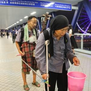 « We are a couple from China, from a poor village in the province of Hunan. I am 54 years old and I used to play part time music in the village. My wife and I have a farm in the village but that’s not enough to make a living, we only earn RMB60 per month, even less especially after we are old now and start to have eyes and legs problems. We used to play music and beg for money in Guangzhou. But that only made several ten RMB more a month. so we decided to take trains to come to hong kong. Here we can earn about HK$200 each day! Today is our 4th day and we have to leave 3 days later. after that we may enjoy a bit of life back home and later we may come back again for begging. since I’m a real blind, the government has issued me a ‘disable certificate’ by which I can have all free travel inside the country, and I can have half price discount for my ticket to hong kong. with this card no one can bully me or kick me out from any kind of transportation. » « We are a couple from China, from a poor village in the province of Hunan. I am 54 years old and I used to play part time music in the village. My wife and I have a farm in the village but that’s not enough to make a living, we only earn RMB60 per month, even less especially after we are old now and start to have eyes and legs problems. We used to play music and beg for money in Guangzhou. But that only made several ten RMB more a month. so we decided to take trains to come to hong kong. Here we can earn about HK$200 each day! Today is our 4th day and we have to leave 3 days later. after that we may enjoy a bit of life back home and later we may come back again for begging. since I’m a real blind, the government has issued me a ‘disable certificate’ by which I can have all free travel inside the country, and I can have half price discount for my ticket to hong kong. with this card no one can bully me or kick me out from any kind of transportation. »