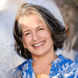PIcture of Dr. Ferguson wearing blue shirt and red and blue flowered shawl, standing in front of columns in Balboa Park, San Diego. Photo Credit: Xavier Bailey Photography PIcture of Dr. Ferguson wearing blue shirt and red and blue flowered shawl, standing in front of columns in Balboa Park, San Diego. Photo Credit: Xavier Bailey Photography