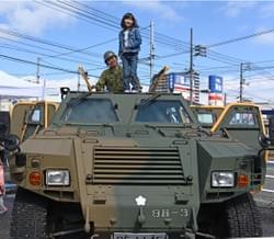 自衛隊の車の屋根でポーズをとる少女 自衛隊の車の屋根でポーズをとる少女