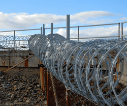 Razor wire under a pale blue sky Razor wire under a pale blue sky