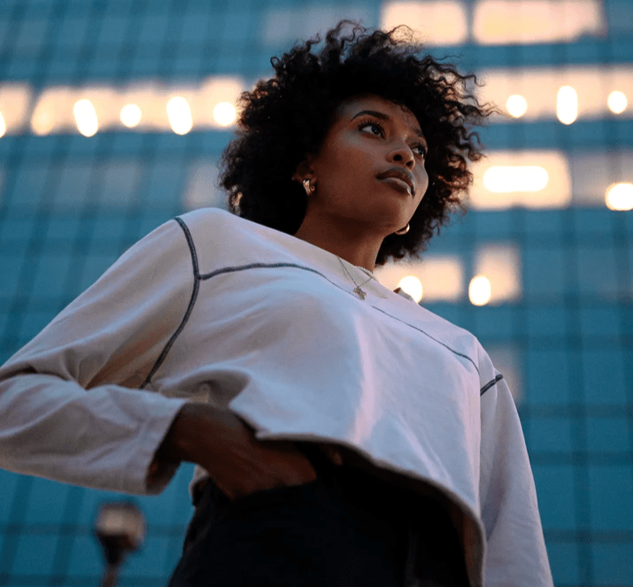 Woman_standing_in_front_of_real_estate_building Woman_standing_in_front_of_real_estate_building