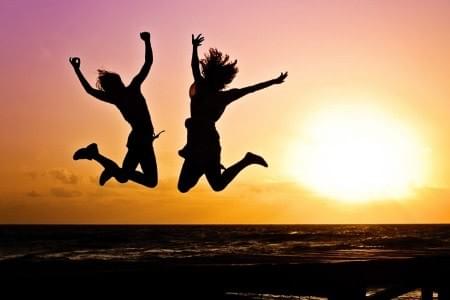 Two people jumping in excitement because they thrive at work Two people jumping in excitement because they thrive at work