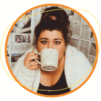 Christina Peña, wearing a fluffy white cardigan, sips from a mug. Behind her is a background of wallpaper made from newspaper. Christina Peña, wearing a fluffy white cardigan, sips from a mug. Behind her is a background of wallpaper made from newspaper.