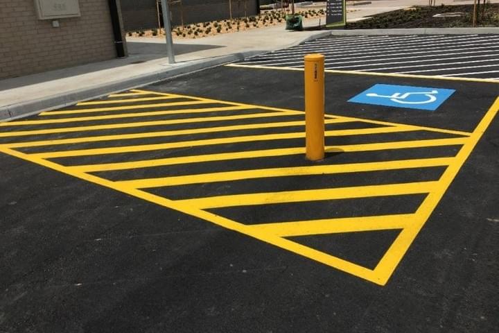 Disability accessible car parking space, as per AS/NZS 2890.6, with yellow line marking and yellow bollard Disability accessible car parking space, as per AS/NZS 2890.6, with yellow line marking and yellow bollard
