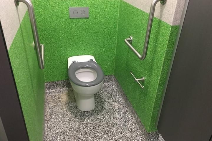 A view inside an ambulant toilet cubicle, showing the toilet pan, grabrails, grey seat and toilet roll holder A view inside an ambulant toilet cubicle, showing the toilet pan, grabrails, grey seat and toilet roll holder