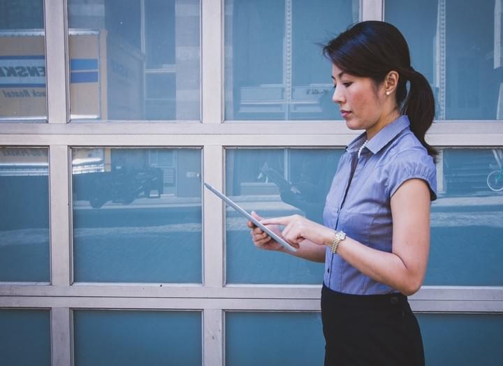 A female DDA Access Consultant. standing looking at her tablet PC while inspecting a building A female DDA Access Consultant. standing looking at her tablet PC while inspecting a building