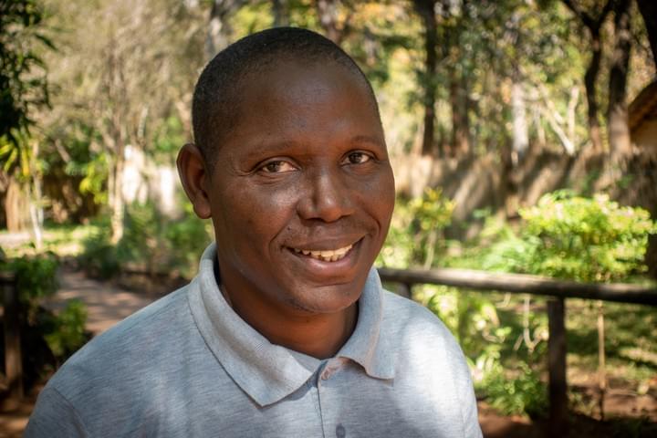 Nekacheya Travel and Tours  guide Herbert   with Zebras in the background  Nekacheya Travel and Tours  guide Herbert   with Zebras in the background