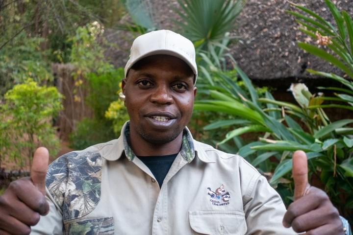 Nekacheya Travel and Tours  guide Herbert   with Zebras in the background  Nekacheya Travel and Tours  guide Herbert   with Zebras in the background