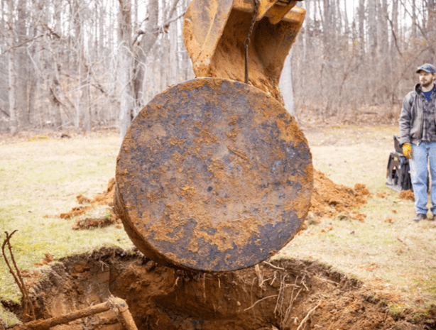 A residential heating oil storage tank is being lifted from the ground with the team standing by. A residential heating oil storage tank is being lifted from the ground with the team standing by.