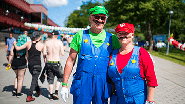 En glad cosplayare med en klänning och vingar gjorda av pokémon-kort. En glad cosplayare med en klänning och vingar gjorda av pokémon-kort.