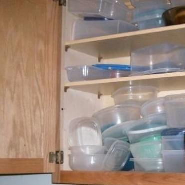multiple mis-matched food storage containers shown in a cupboard multiple mis-matched food storage containers shown in a cupboard