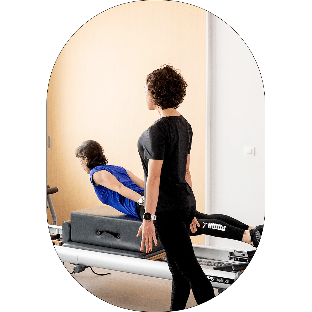 fotografia de una mujer haciendo pilates en una máquina con la profesora al lado fotografia de una mujer haciendo pilates en una máquina con la profesora al lado