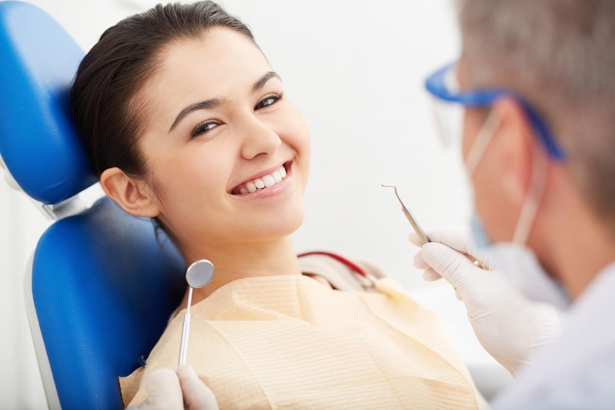 Smiling Young Woman being Examined by Dentist Excited about Compounded Dental Medications from InHealth Specialty Pharmacy Fargo, ND Smiling Young Woman being Examined by Dentist Excited about Compounded Dental Medications from InHealth Specialty Pharmacy Fargo, ND