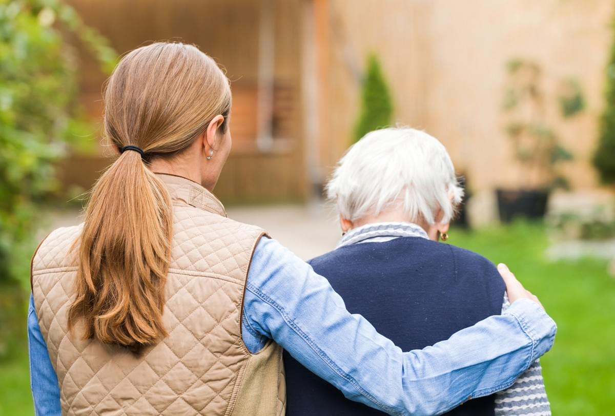 Young Woman with her Arm aroudn Elderly Person Young Woman with her Arm aroudn Elderly Person