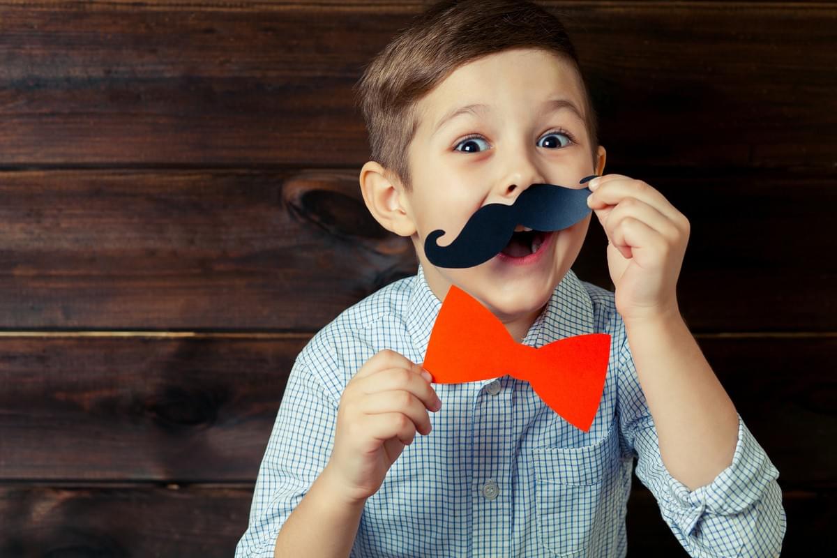 Funny Young Boy Playing around with Play Bow Tie and Mustache Funny Young Boy Playing around with Play Bow Tie and Mustache