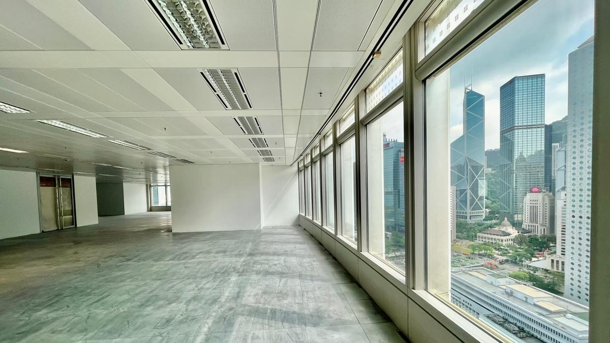 Bare-shell Grade-A office floor reinstated by Agrey, showing exposed concrete slab and full-height windows overlooking Central Hong Kong skyline Bare-shell Grade-A office floor reinstated by Agrey, showing exposed concrete slab and full-height windows overlooking Central Hong Kong skyline