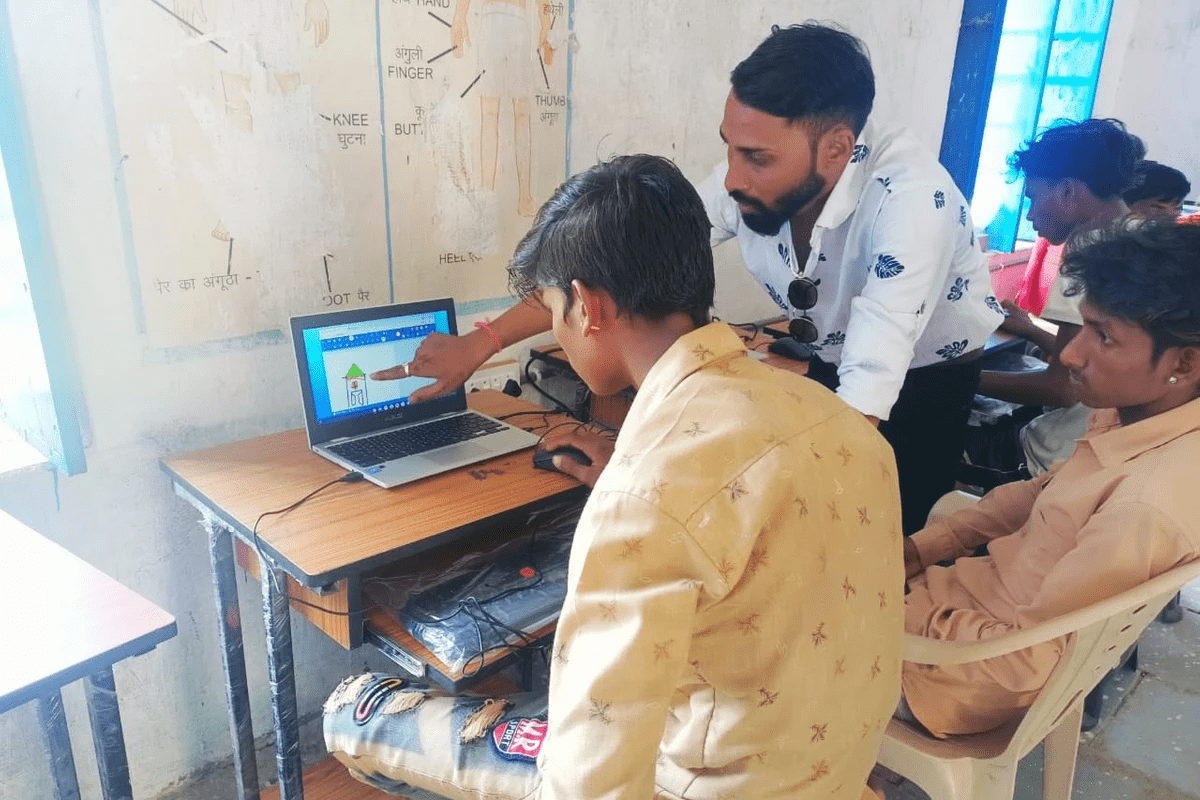Two students being taught how to use a computer by a diganth facilitator. Two students being taught how to use a computer by a diganth facilitator.