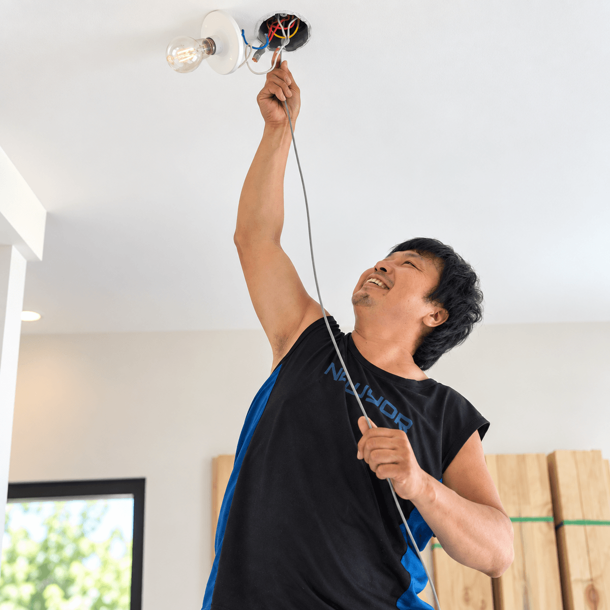 桃園水電工班師傅仰頭進行天花板電線配線與燈具出線迴路施工。 桃園水電工班師傅仰頭進行天花板電線配線與燈具出線迴路施工。