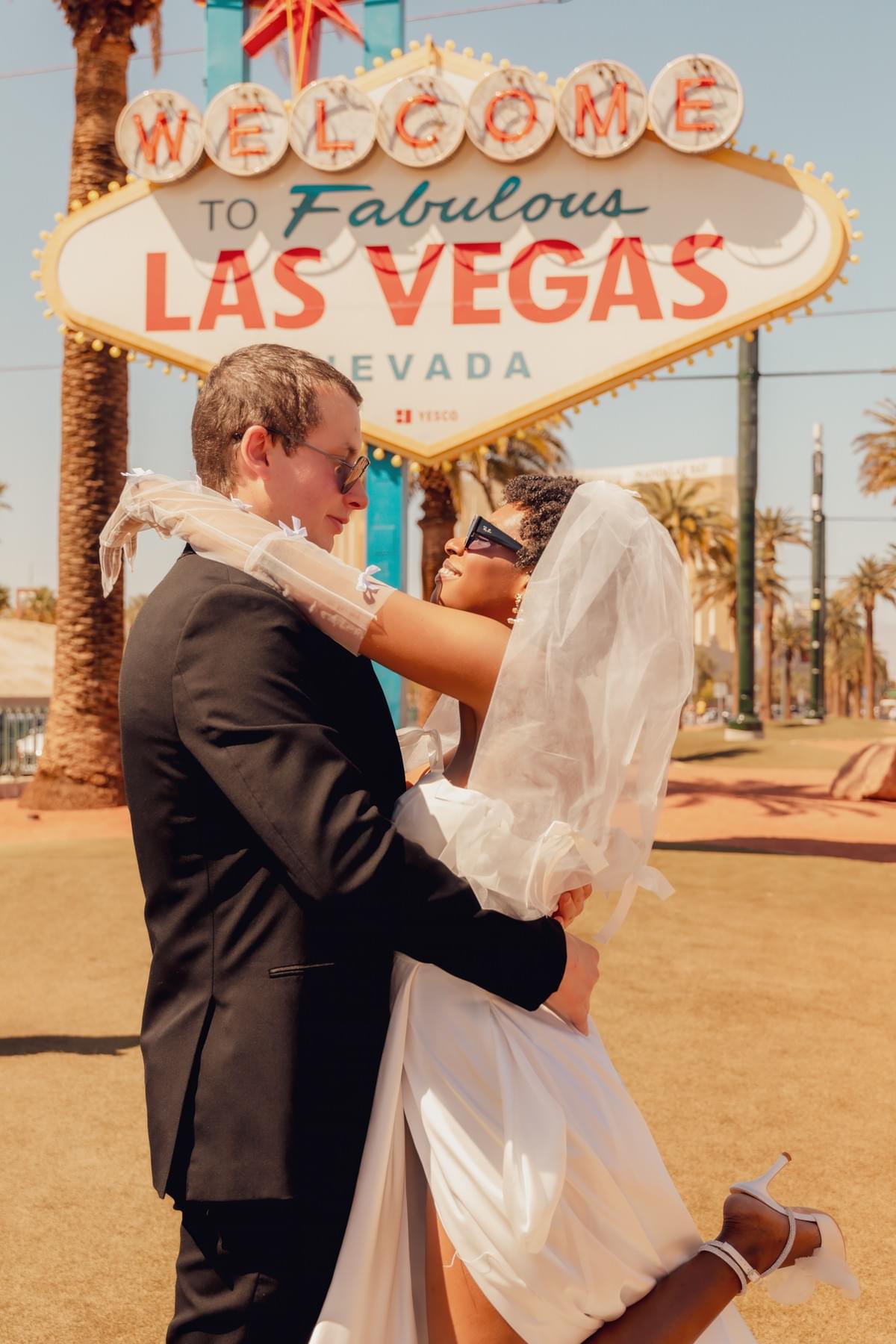 Couple posing together in front of the iconic Welcome to Las Vegas sign at night, capturing vibrant lights and a classic Vegas vibe. Couple posing together in front of the iconic Welcome to Las Vegas sign at night, capturing vibrant lights and a classic Vegas vibe.