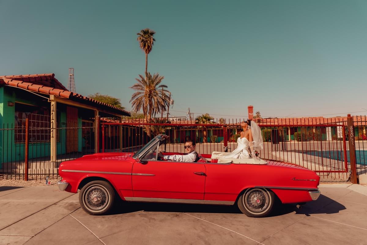 Newlywed couple sitting in a vintage red Cadillac outside Sure Thing Chapel in Las Vegas during their Drive Thru wedding. Newlywed couple sitting in a vintage red Cadillac outside Sure Thing Chapel in Las Vegas during their Drive Thru wedding.