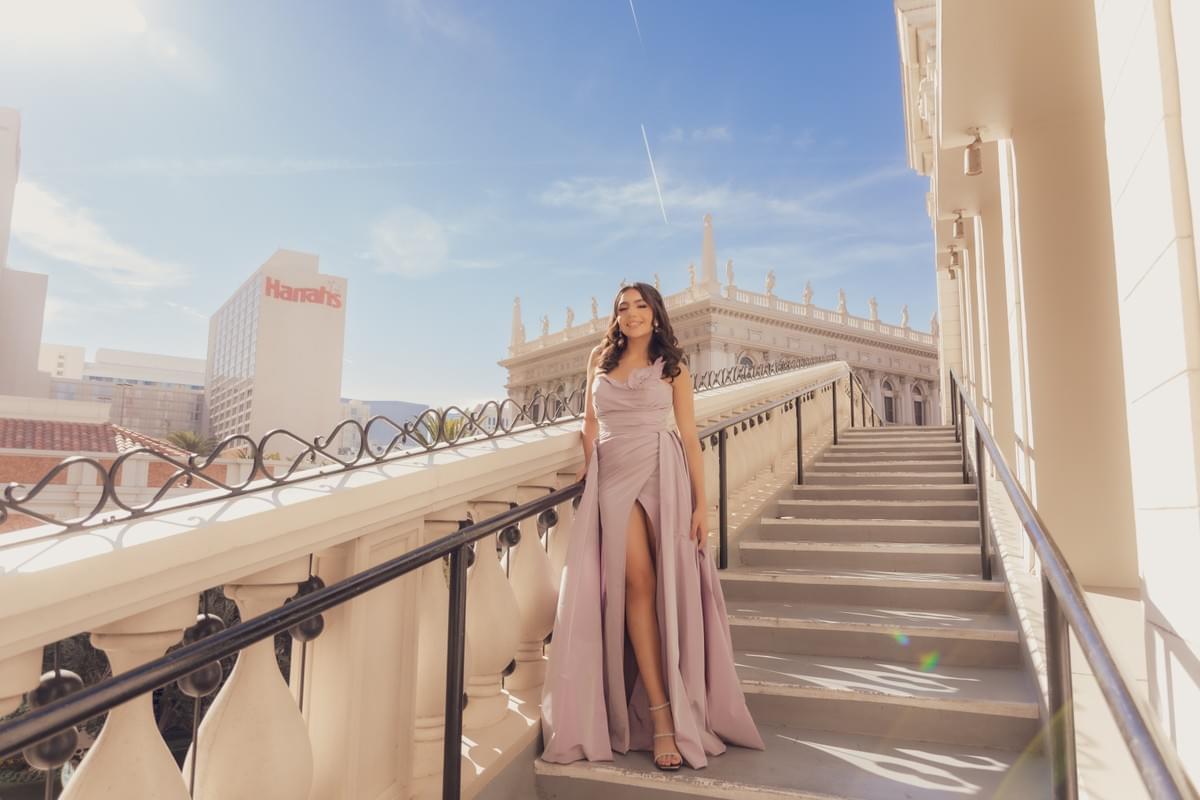 Woman sitting on steps along the Las Vegas Strip during the day, capturing the bustling city atmosphere and iconic hotel backdrops. Woman sitting on steps along the Las Vegas Strip during the day, capturing the bustling city atmosphere and iconic hotel backdrops.