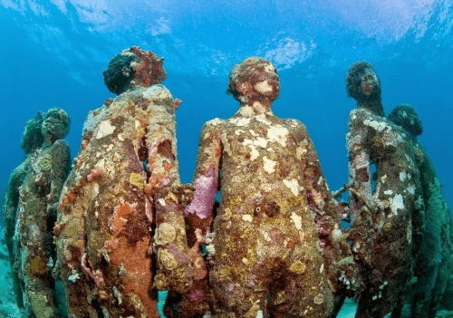 Underwater sculpture of women in a circle holding hands. They are covered in barnacles Underwater sculpture of women in a circle holding hands. They are covered in barnacles