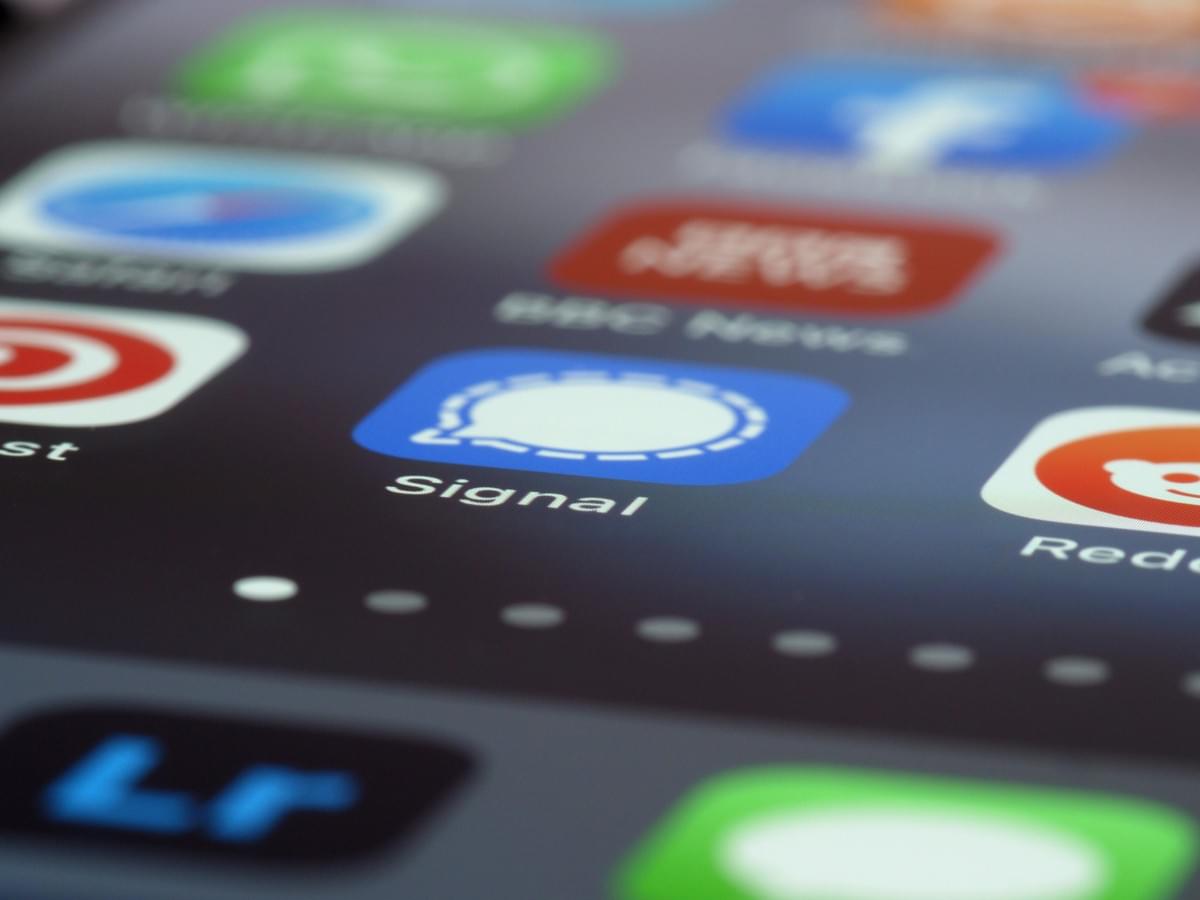 A close-up view of a smartphone screen displaying several app icons, with the central focus on the blue “Mail” app icon featuring a white envelope. A red notification badge with the number “2” appears in the top-right corner of the icon, indicating two unread emails. Surrounding the Mail icon are partial views of other apps, including a news app and the BBC News app, suggesting a mix of communication and information tools. The image highlights mobile connectivity and digital engagement, emphasizing themes of responsiveness, information flow, and the everyday presence of technology in personal and professional life A close-up view of a smartphone screen displaying several app icons, with the central focus on the blue “Mail” app icon featuring a white envelope. A red notification badge with the number “2” appears in the top-right corner of the icon, indicating two unread emails. Surrounding the Mail icon are partial views of other apps, including a news app and the BBC News app, suggesting a mix of communication and information tools. The image highlights mobile connectivity and digital engagement, emphasizing themes of responsiveness, information flow, and the everyday presence of technology in personal and professional life