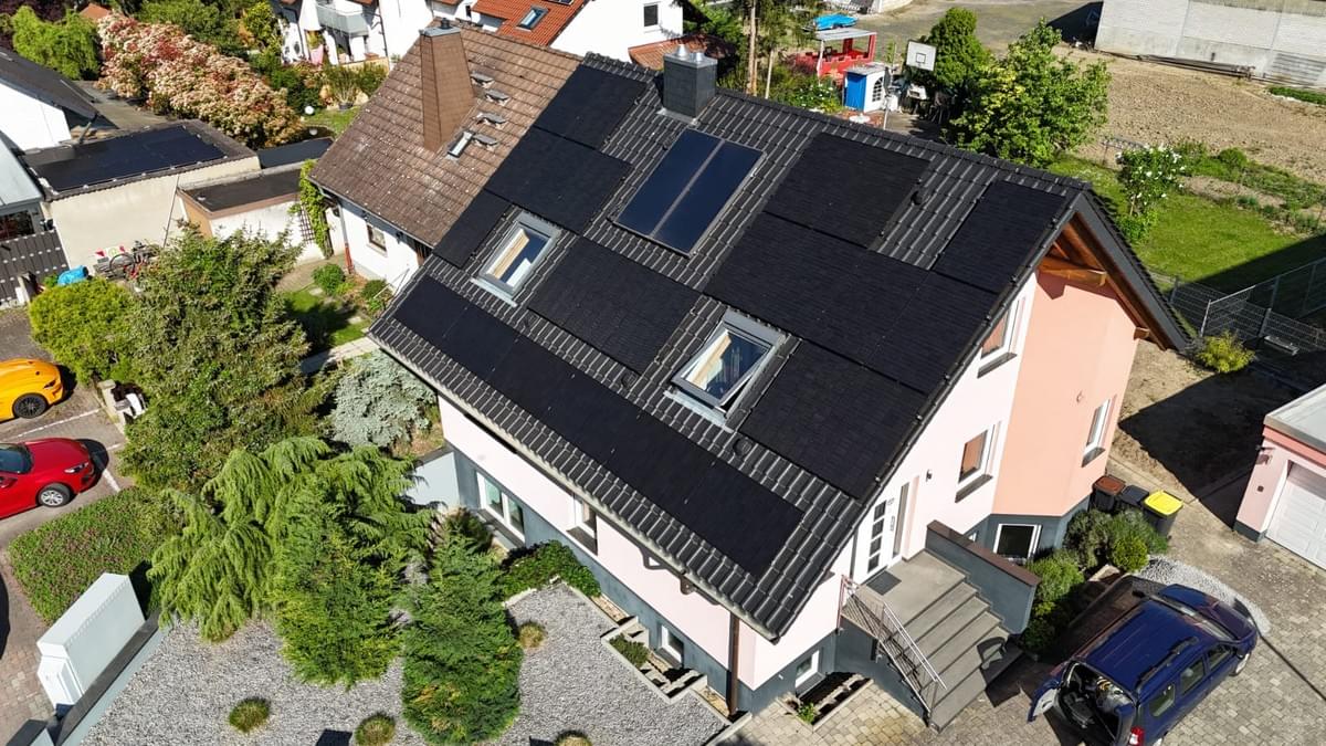 Europäisches Wohnhausdach mit installierten vollschwarzen monokristallinen PV-Modulen – hohe Effizienz vereint mit architektonischer Ästhetik Europäisches Wohnhausdach mit installierten vollschwarzen monokristallinen PV-Modulen – hohe Effizienz vereint mit architektonischer Ästhetik