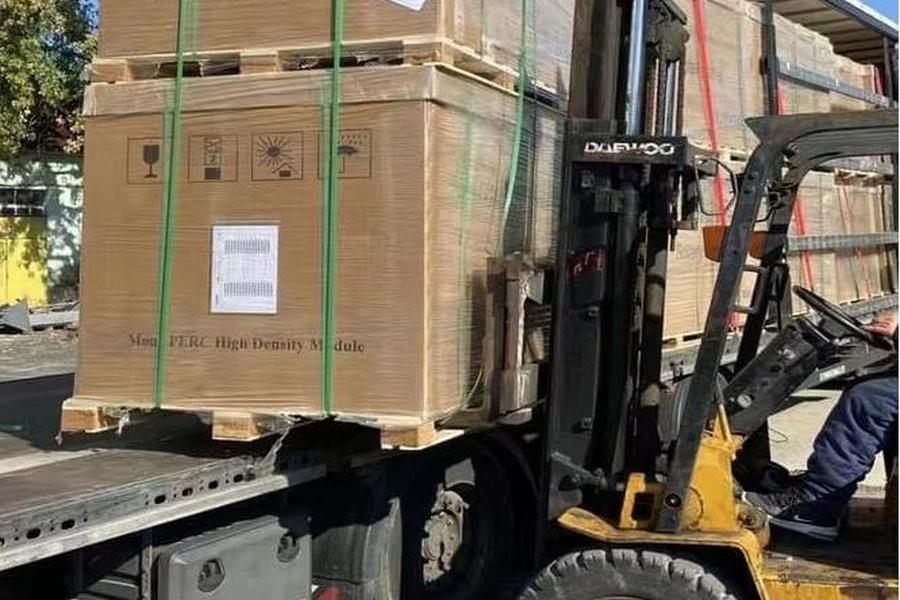 Il carrello elevatore sta scaricando i moduli fotovoltaici dal camion, mostrando il processo di stoccaggio e consegna nei passaggi di distribuzione e commercio all’ingrosso. Il carrello elevatore sta scaricando i moduli fotovoltaici dal camion, mostrando il processo di stoccaggio e consegna nei passaggi di distribuzione e commercio all’ingrosso.