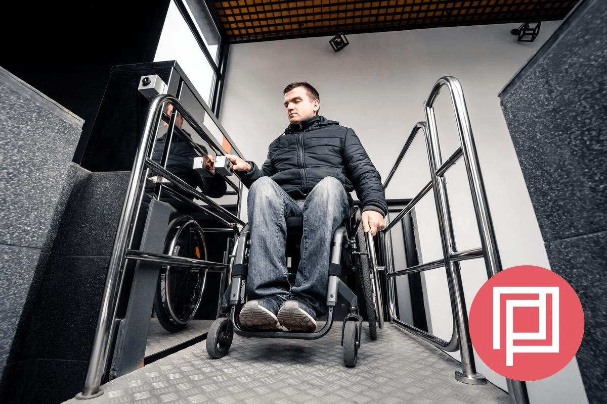 Portrait of a man using a wheelchair smiling next to some columns in a doorway with logo Portrait of a man using a wheelchair smiling next to some columns in a doorway with logo