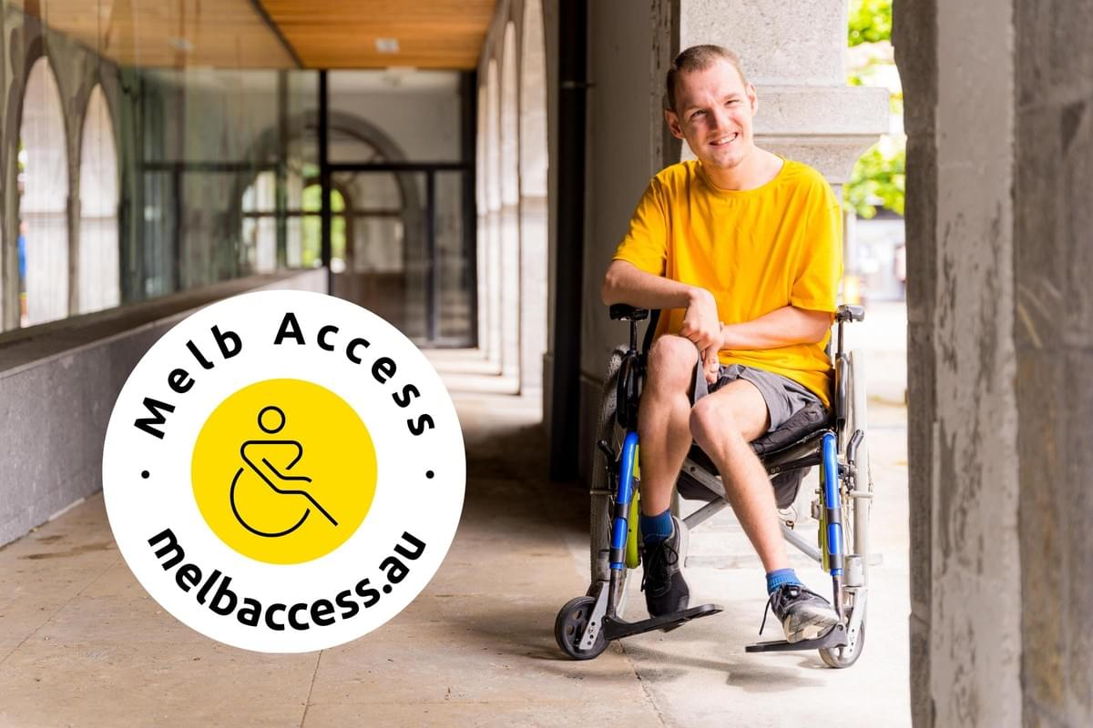 Portrait of a man using a wheelchair smiling next to some columns in a doorway with logo Portrait of a man using a wheelchair smiling next to some columns in a doorway with logo