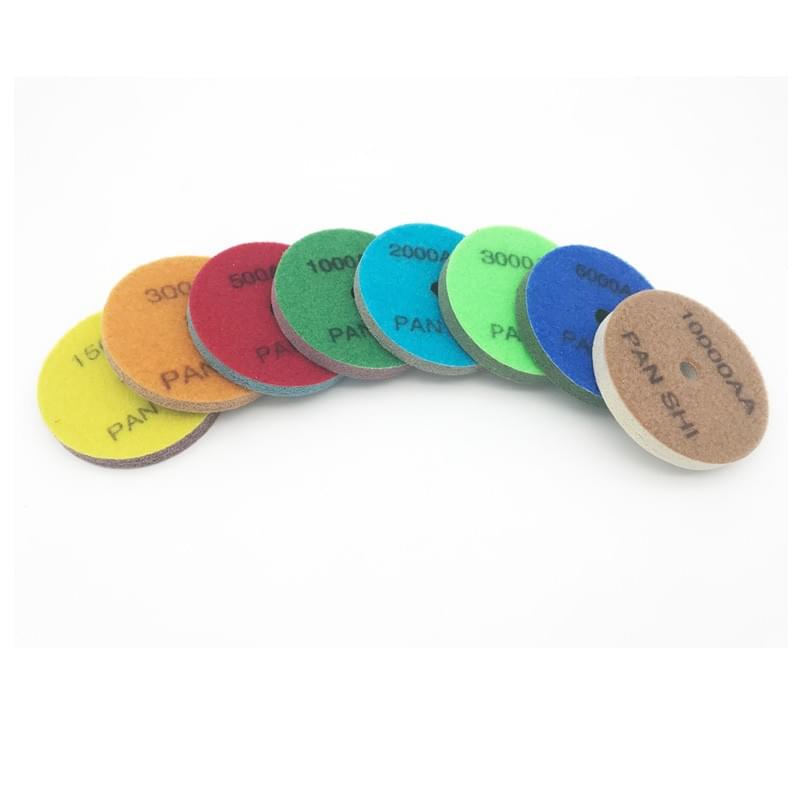 Eight coloured diamond sponge polishing pads marked 150 to 10000 grit, arranged in an overlapping row on a white background Eight coloured diamond sponge polishing pads marked 150 to 10000 grit, arranged in an overlapping row on a white background
