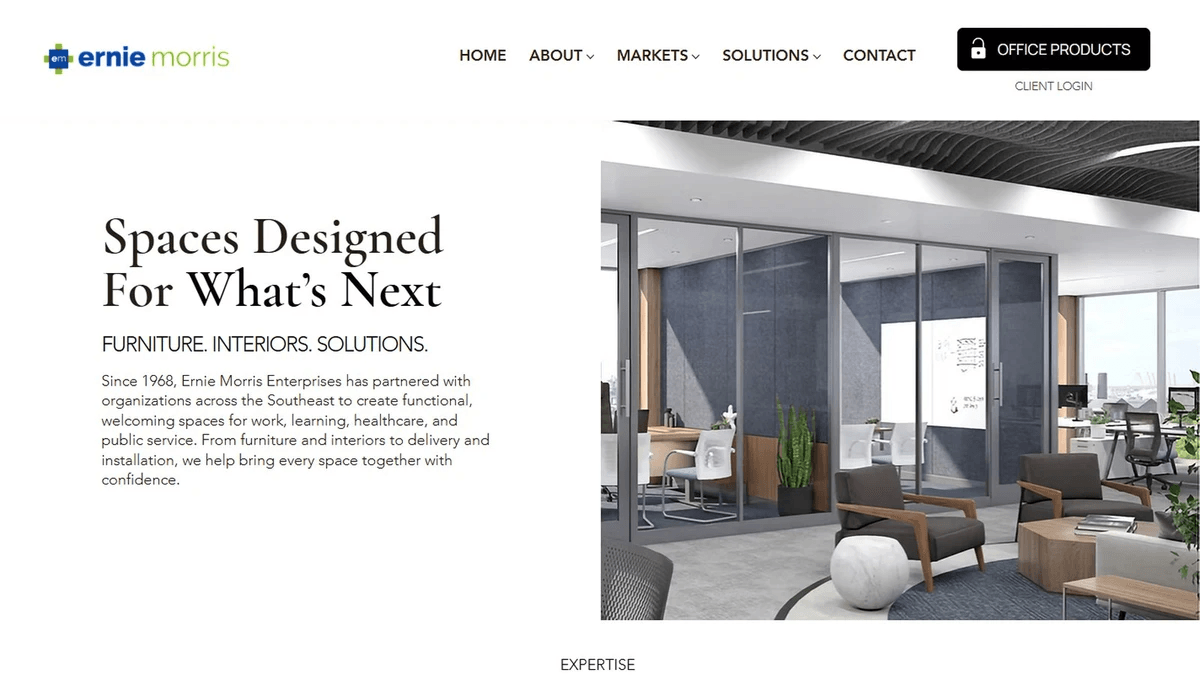 Ernie Morris Enterprises website homepage with the headline "Spaces Designed For What's Next" next to a modern office interior with glass walls and lounge seating Ernie Morris Enterprises website homepage with the headline "Spaces Designed For What's Next" next to a modern office interior with glass walls and lounge seating
