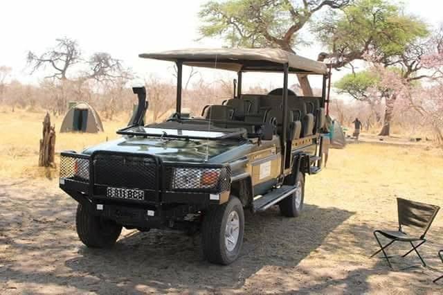 A game drive vehicle parked in the bush, ready for an exciting safari adventure with tourists. A game drive vehicle parked in the bush, ready for an exciting safari adventure with tourists.